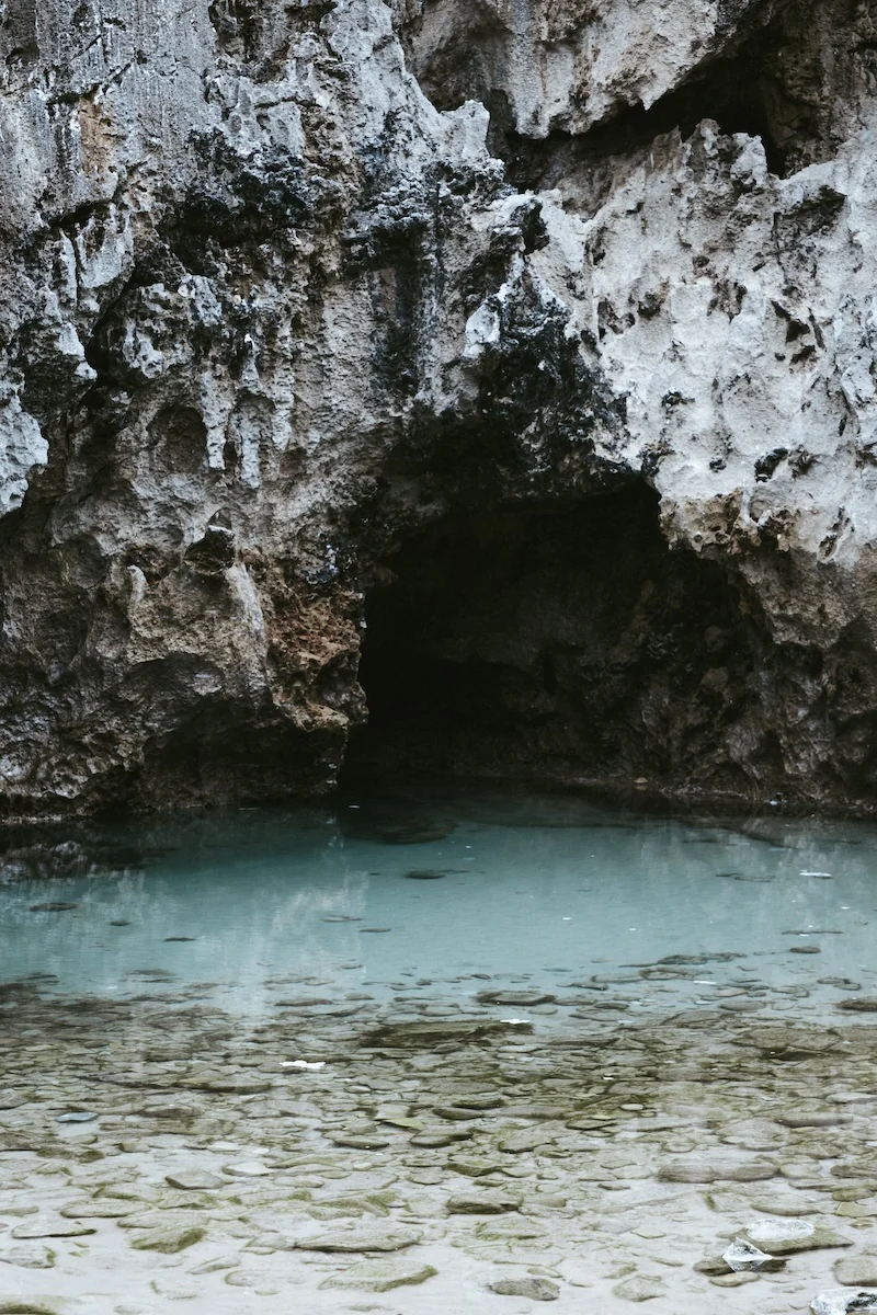 Detalle de la entrada de la cueva con agua turquesa en Cobijeru