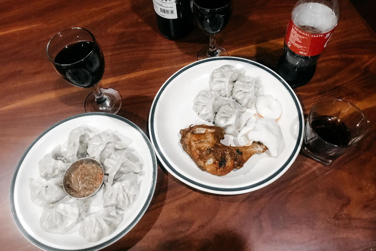 Momos nepalíes servidos en un plato con salsa picante