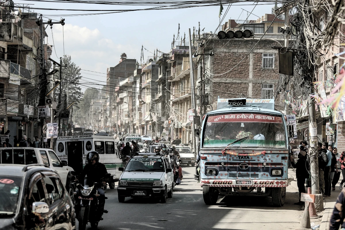 Tráfico en Katmandú con autobuses decorados y calles polvorientas